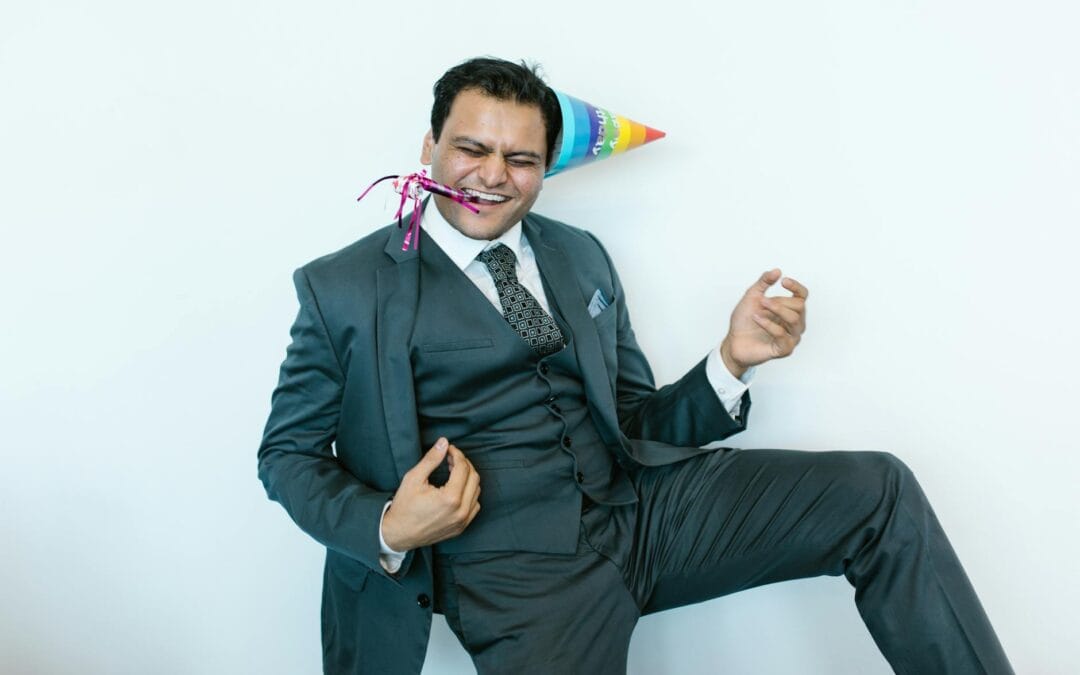 man in suit jacket wearing a party hat